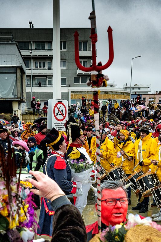 Carnavaleux illuminés par les lumières de la ville pendant le défilé nocturne du Carnaval de Dunkerque.