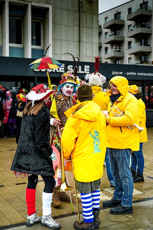 Gros plan sur masques carnavalesques ornés de plumes multicolores et maquillage extravagant.