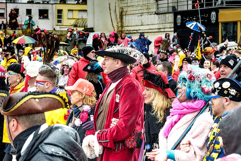 Carnavaleux illuminés par les lumières de la ville pendant le défilé nocturne du Carnaval de Dunkerque.