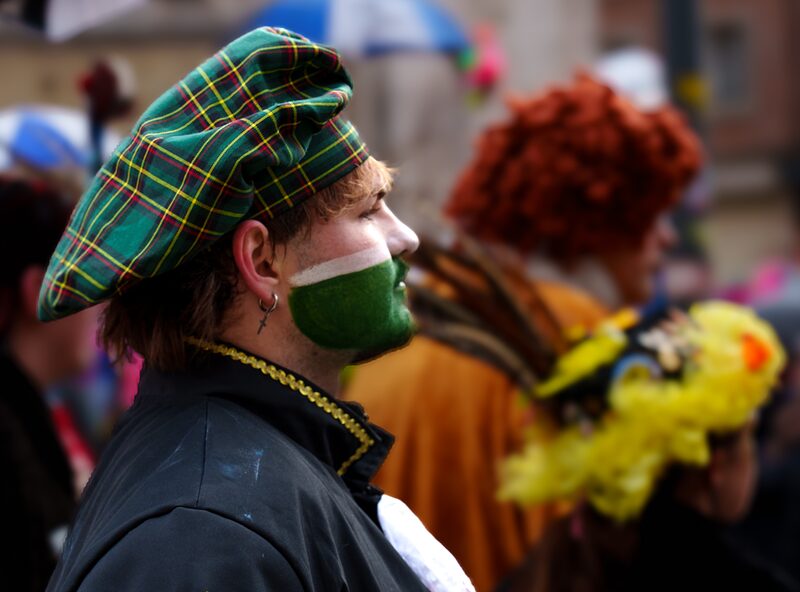 Carnavaleux en costumes et couvre-chef vert défilant dans les rues de Dunkerque 2026.