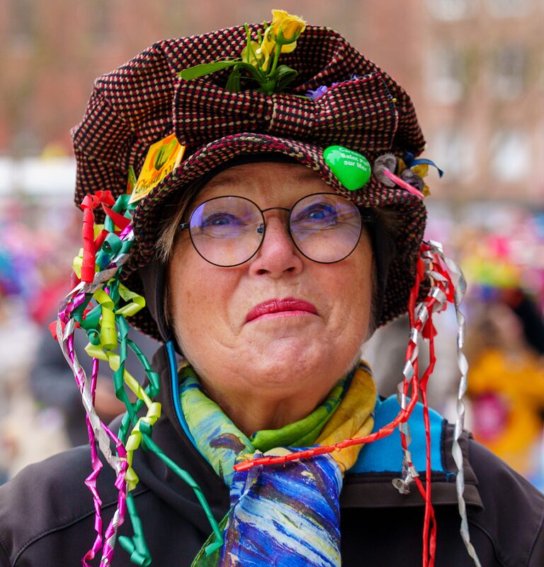 Carnavaleux illuminés par les lumières de la ville pendant le défilé nocturne du Carnaval de Dunkerque.