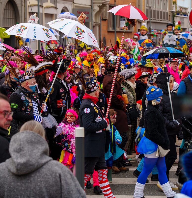 Carnavaleux illuminés par les lumières de la ville pendant le défilé nocturne du Carnaval de Dunkerque.