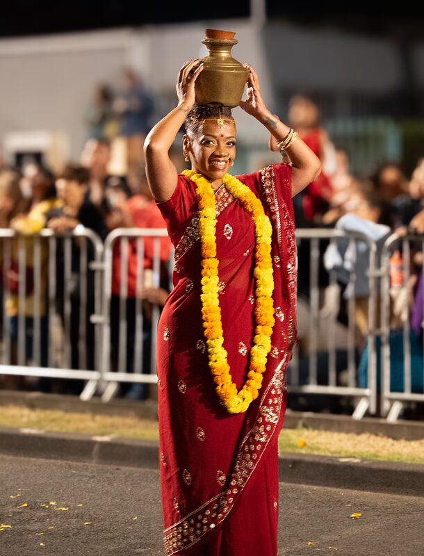 Jeune femme indienne défilant avec un collier de fleurs jaunes lors de la fête des lumière 2025 à Saint-André, Réunion.