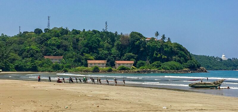 Groupe de pêcheurs et de badeaux tirant sur le riva un filet de pêche, Sri-Lanka 2016.