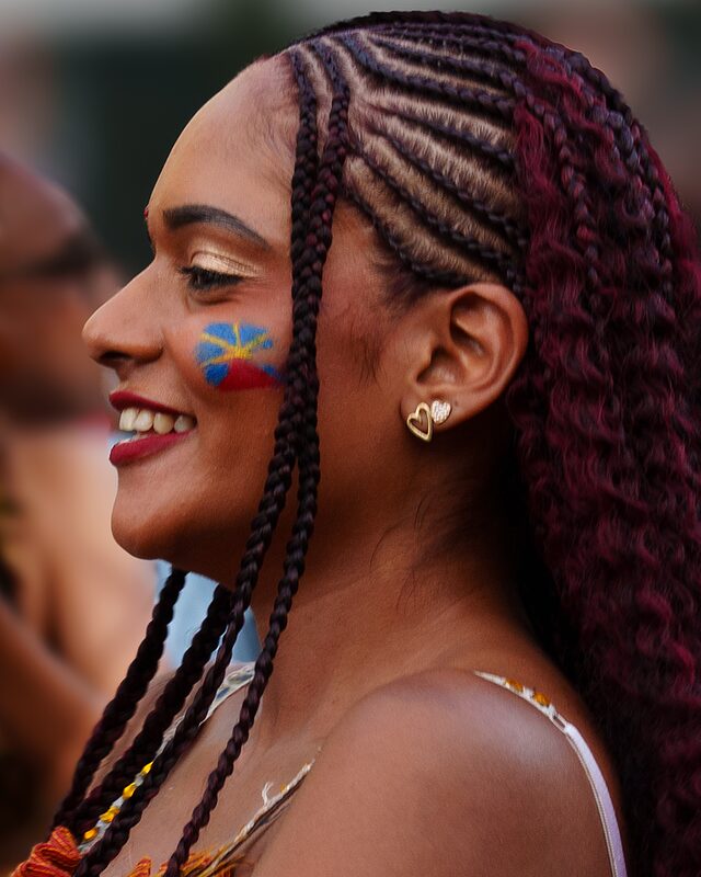 Une jeune femme réunionnaise avec les couleurs de la Réunion peintes sur sa joue gauche, Réunion 2025.