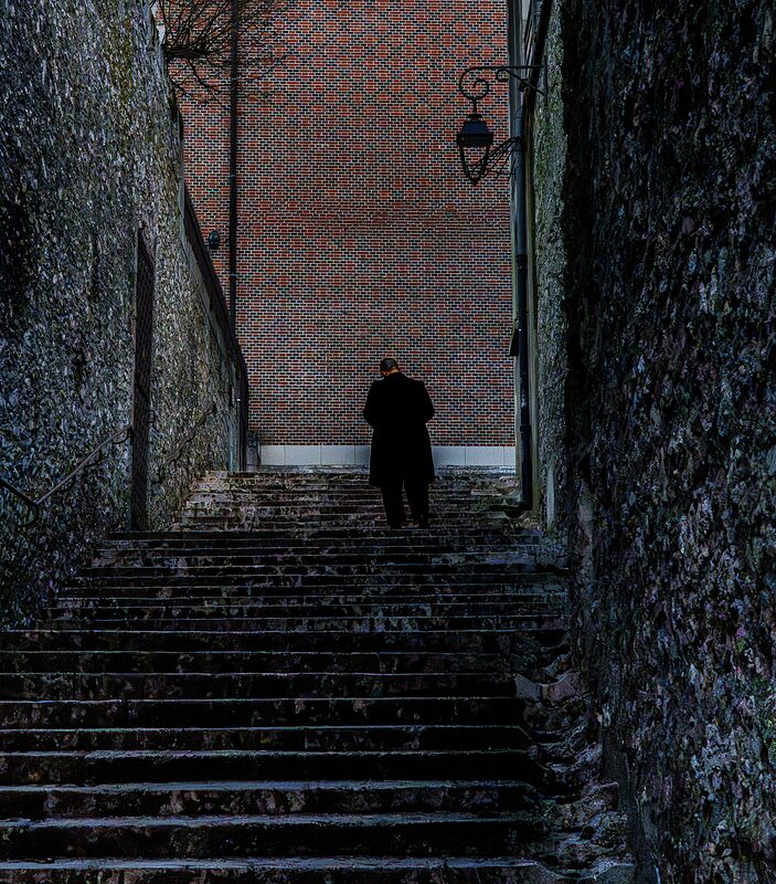 Un passant déambulant dans une ruelle d'escalier dans le vieux Blois.