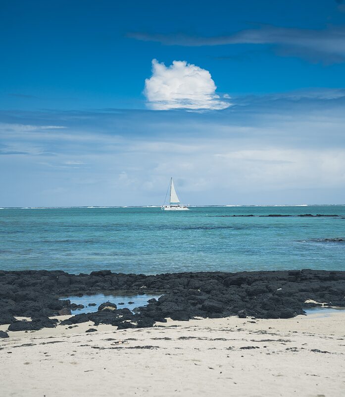 Voilier vue depuis les côtes des cinq îles, sur un océan turqouise et un ciel bleu,  Ile Maurice 2026.